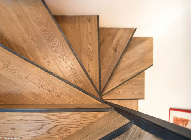 Scala a chiocciola in legno vista dall’alto con design moderno.